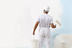 painter man at work with a paint roller and bucket, wall painting concept